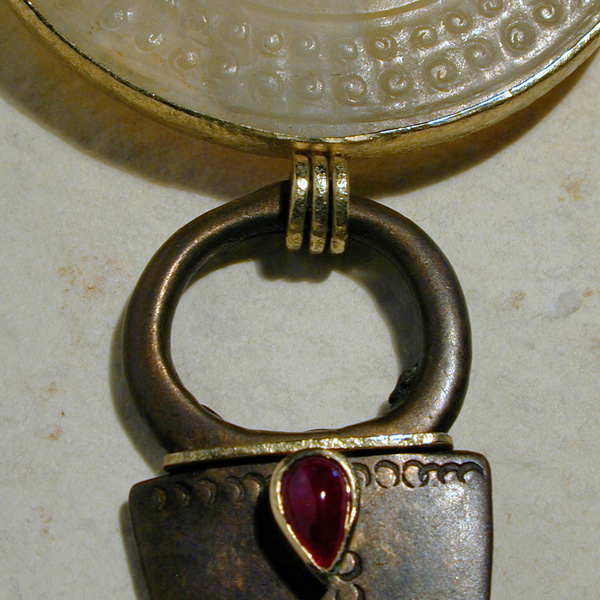 Pendente in giada, rubino cabochon, bronzo Dogon